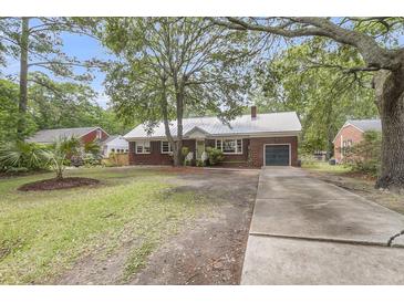 Charming brick home with a metal roof, well-maintained landscaping, and long concrete driveway at 1534 Salisbury St, Charleston, SC 29407