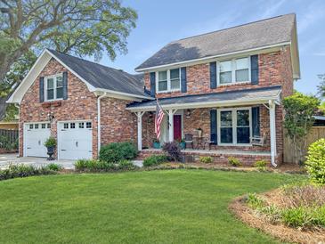 Charming brick home featuring a cozy front porch, well-manicured lawn, and inviting curb appeal at 16 Charlyn Dr, Charleston, SC 29407
