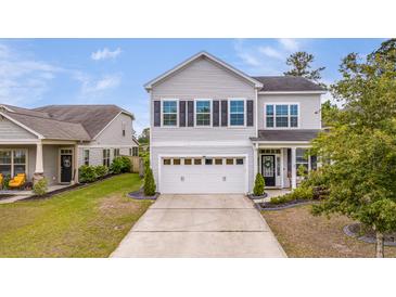 Charming two-story home featuring a white garage door and beautiful landscaping, curb appeal at 209 Palmetto Walk Dr, Summerville, SC 29486