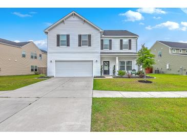 Charming two-story home with a well-manicured lawn, attached garage, and classic white siding at 306 Lucca Dr, Summerville, SC 29486