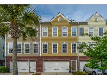 Charming townhome with colorful facade, two-car garage, and palm tree in the landscaped front yard at 3517 Claremont St, Mount Pleasant, SC 29466