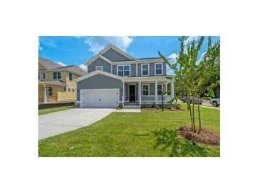 Two-story home featuring a gray exterior, well-maintained lawn, and a concrete driveway leading to an attached garage at 389 Wappoo Trace Ln, Summerville, SC 29486