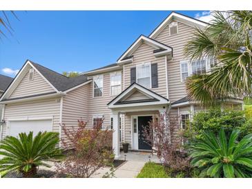 Charming two-story home showcasing a manicured lawn, complemented by lush landscaping and a welcoming front entrance at 5258 Mulholland Dr, Summerville, SC 29485