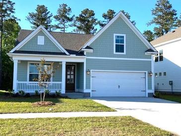 Charming, light-blue, one-story home featuring a two-car garage, manicured lawn, and welcoming front porch at 761 Maynard Ln, Summerville, SC 29486