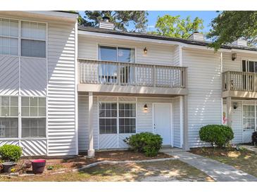 Charming two-story townhome featuring a balcony and a well-maintained front yard with a sidewalk leading to the front door at 7838 Nummie Ct, North Charleston, SC 29418