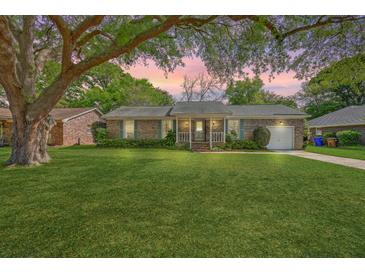 Charming brick home with a lush green lawn and mature tree in a peaceful neighborhood setting at 816 Farnham Rd, Charleston, SC 29412