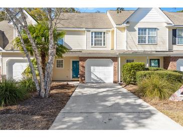 Charming townhome featuring a one car garage, a blue front door and mature trees at 8653 Grassy Oak Trl, North Charleston, SC 29420