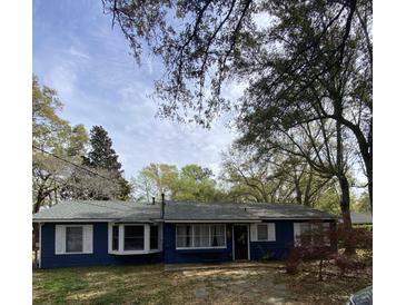Charming blue home with white trim, manicured lawn, and mature trees at 1018 Bradford Ave, Charleston, SC 29412
