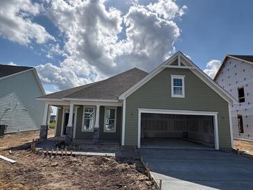 Charming single-story home featuring a two-car garage, covered porch, and green siding at 109 Crosscut Ln, Summerville, SC 29486