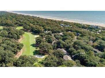 An aerial view of the property showing its proximity to a golf course, lush vegetation, and the beach at 1365 Dunlin Court, Share D, Kiawah Island, SC 29455