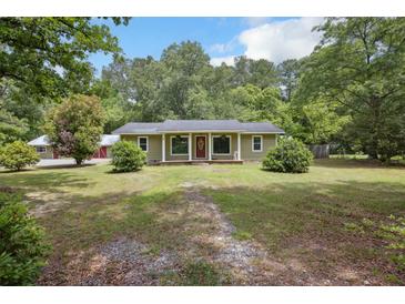 Charming single-story home with a welcoming red door, surrounded by lush greenery and a well-maintained lawn at 158 Whippoorwill Dr, Summerville, SC 29483