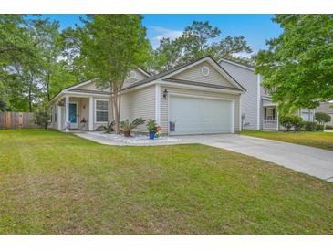 Charming single-story home with a well-manicured lawn, attached garage, and beautiful landscaping at 2427 Stingray Blvd, North Charleston, SC 29406