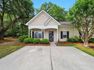 Charming single-story home with a cozy front porch and well-manicured landscaping at 325 Dupont Way, Summerville, SC 29485