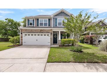 Charming two-story home featuring stone accents, a two-car garage, and a well-maintained lawn at 3321 Tabard Rd, Johns Island, SC 29455