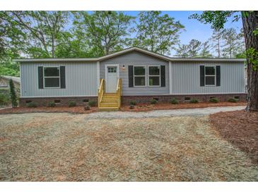 Charming single story home showcasing a gravel yard and wooden steps leading to the front door at 409 Peacock Ln, Summerville, SC 29483