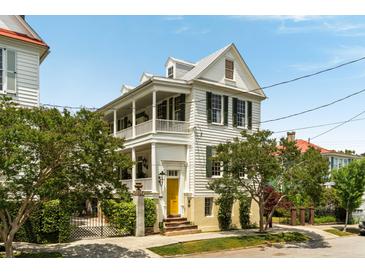 Charming two-story home with double porches, yellow front door, and mature landscaping at 6 Judith St, Charleston, SC 29403
