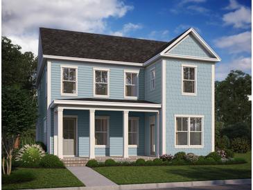 Charming two-story home with light blue siding, white trim, a welcoming porch, and beautifully landscaped front yard at 740 Blueway Ave, Summerville, SC 29486