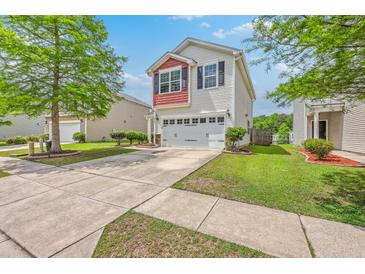 Charming two-story home with a white exterior, red accents, and a well-manicured lawn in a suburban neighborhood at 9707 Seed St, Ladson, SC 29456