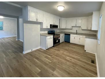 Bright kitchen features white cabinets, granite countertops and new flooring at 1070 French Quarter Creek Rd, Huger, SC 29450