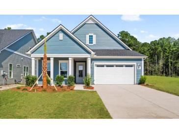 Charming single-story home featuring a two-car garage, blue siding, and a well-manicured front lawn at 139 Summerwind Dr, Summerville, SC 29486