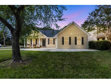 Charming single-story home featuring a well-maintained lawn and inviting curb appeal at sunset at 1725 Henley Ln, Charleston, SC 29412