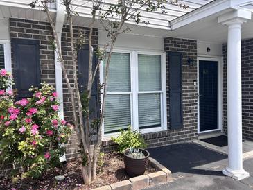 Charming brick townhome with dark shutters and blooming roses at 1735 Boone Hall Dr # K6, Charleston, SC 29407