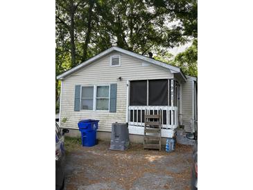Exterior of a small single-story home featuring a screened porch and light-colored siding at 1921 Quitman St, North Charleston, SC 29405