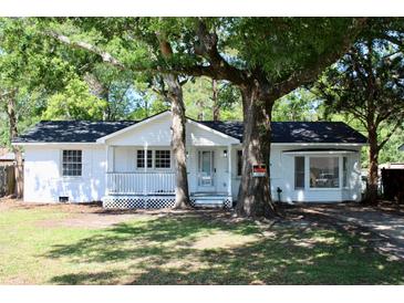 Charming white brick home featuring mature trees, a cozy front porch, and a freshly painted exterior at 227 Amy Dr, Goose Creek, SC 29445