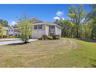 Charming two-story home with a two car garage, manicured landscaping, and a private wooded backyard at 254 Cypress Marsh Rd, Moncks Corner, SC 29461