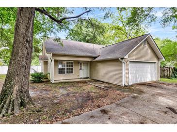 Charming single-story home with attached garage, surrounded by mature trees and a well-maintained lawn at 2919 Fernwood Dr, North Charleston, SC 29406