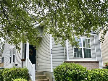 Charming home with gray siding, white trim, inviting entrance, and well-manicured landscaping at 310 Flyway Rd, Goose Creek, SC 29445