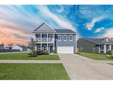 Charming two-story home featuring a welcoming porch, well-manicured lawn, and a two-car garage at 424 Carrara Dr, Summerville, SC 29486