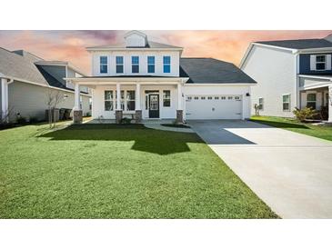 Charming two-story home featuring manicured lawn, two-car garage, and inviting front porch at 490 Rowley Ln, Summerville, SC 29486