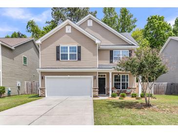 Charming two-story home with a manicured lawn, featuring stone accents and a spacious two-car garage at 5228 Fallow Fawns Rd, Hollywood, SC 29449