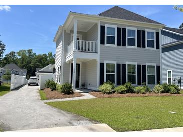 Charming two-story home with a inviting front porch, lush green lawn and manicured landscaping at 104 Pine Waters Ln, Summerville, SC 29483
