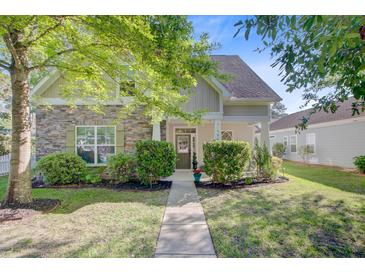 Charming single-Gathering home with stone accents, well-manicured lawn, and inviting curb appeal at 106 Wrigley Blvd, Summerville, SC 29485