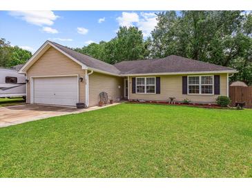 Charming single-story home with a well-maintained lawn and attached garage on a sunny day at 112 Red Cypress Dr, Goose Creek, SC 29445