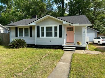 Charming single-story home with light gray siding, black shutters, and a vibrant pink front door at 1159 Camden St, North Charleston, SC 29405