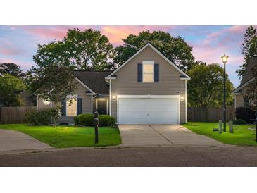 Charming single-Gathering home with a well-manicured lawn and two-car garage at dusk at 129 Mockernut Dr, Ladson, SC 29456