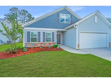 Charming home featuring a two-car garage, a welcoming front yard, and stone accents near the house's entrance at 137 Clydesdale Cir, Summerville, SC 29486