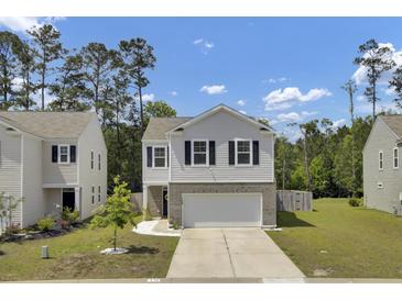 Charming two-story home featuring a gray and white exterior, complemented by a well-maintained front yard at 138 Sweet Cherry Ln, Summerville, SC 29486