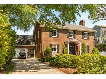 Charming two-story red brick home with black shutters, landscaped yard, and a detached garage at 2 Pierates Cruz, Mount Pleasant, SC 29464