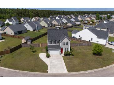 Aerial view of a two-story house with a well-manicured lawn and tree lined street at 2113 Pimlico Dr, Ridgeville, SC 29472