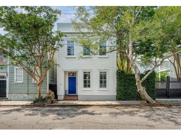 Charming two-story home with a blue front door and beautiful trees in a desirable neighborhood at 23 Felix St, Charleston, SC 29403