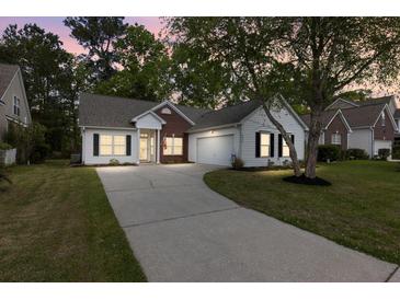 Charming single-story home with a well-manicured lawn, long driveway, and attached garage at 4872 Law Blvd, Summerville, SC 29485