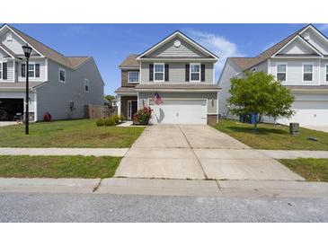 Charming two-story home with a two car garage, manicured lawn and flower beds at 5222 American Holly Ln, Ladson, SC 29456