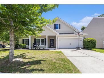 Charming home with manicured lawn, a two-car garage, and a welcoming front porch with rocking chair at 5400 Turning Tide, North Charleston, SC 29420