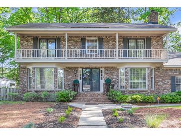 Charming brick home featuring a lovely front yard, covered porch and beautiful second-story balcony at 615 Fairington Dr, Summerville, SC 29485