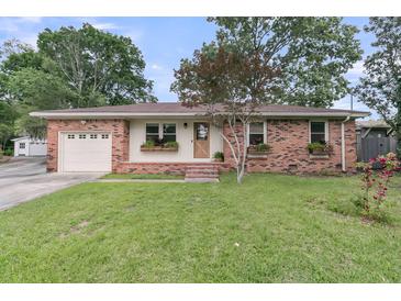Charming brick home featuring well-maintained lawn, flower boxes, and an attached one-car garage at 108 Williamsburg Ct, Goose Creek, SC 29445