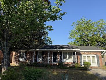 Charming brick home with mature trees and covered front entry at 1138 Landsdowne Dr, Charleston, SC 29412